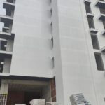 Fasáda rezidence Cold Water Vlora v pokročilé fázi výstavby se stavebním materiálem na terase
